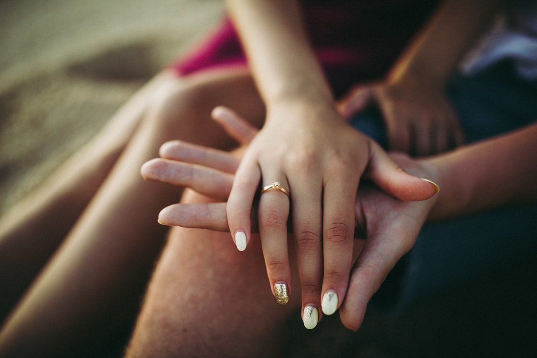 Woman`s hand with a ring on a man`s hand at Nunggalan Beach Nyang Nyang