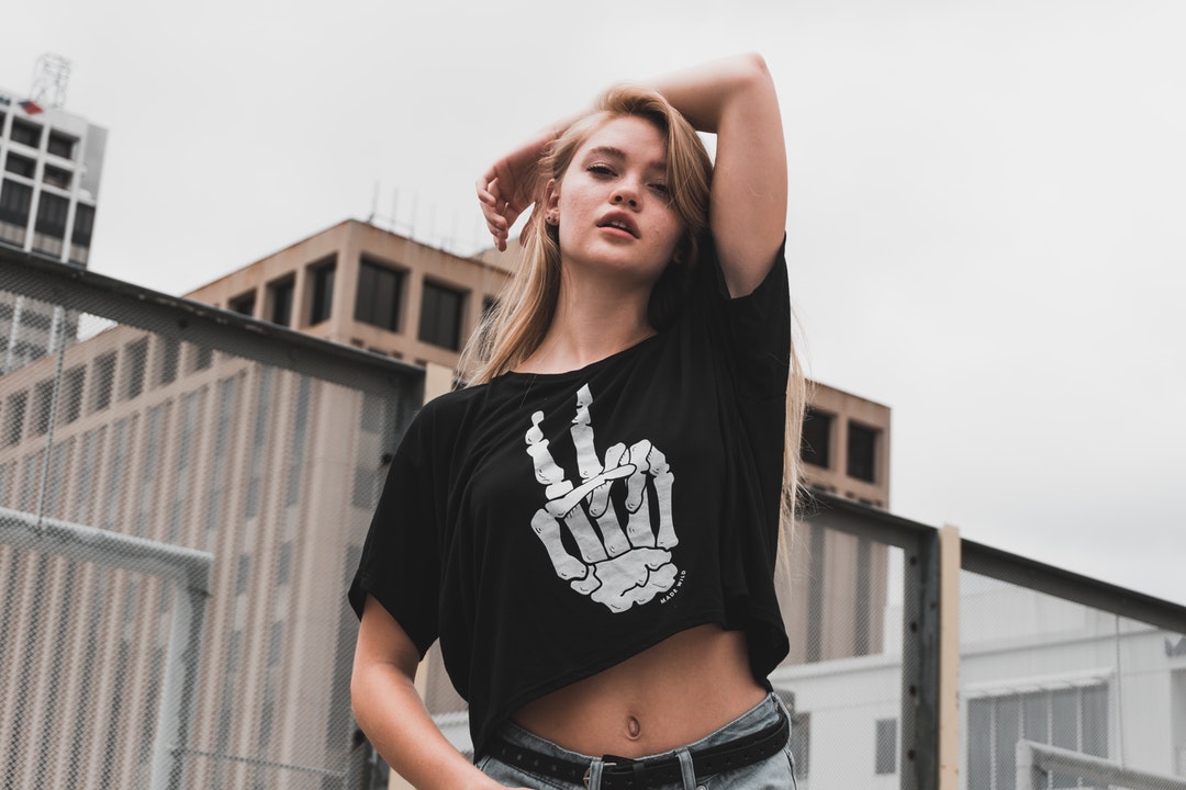 Woman in a skeleton t shirt posing on a rooftop