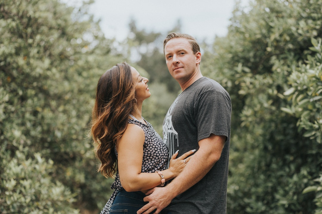 Happy couple embracing in a field of trees