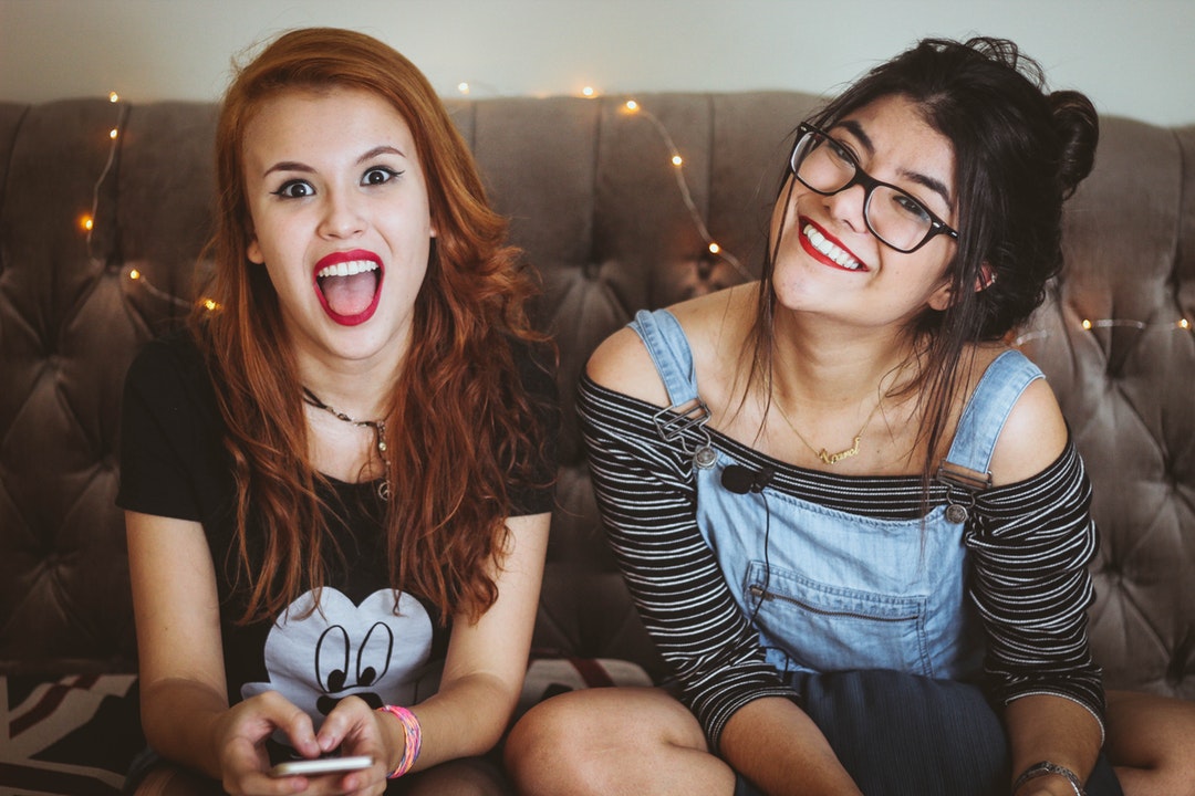 Two girls looking happily at the camera.