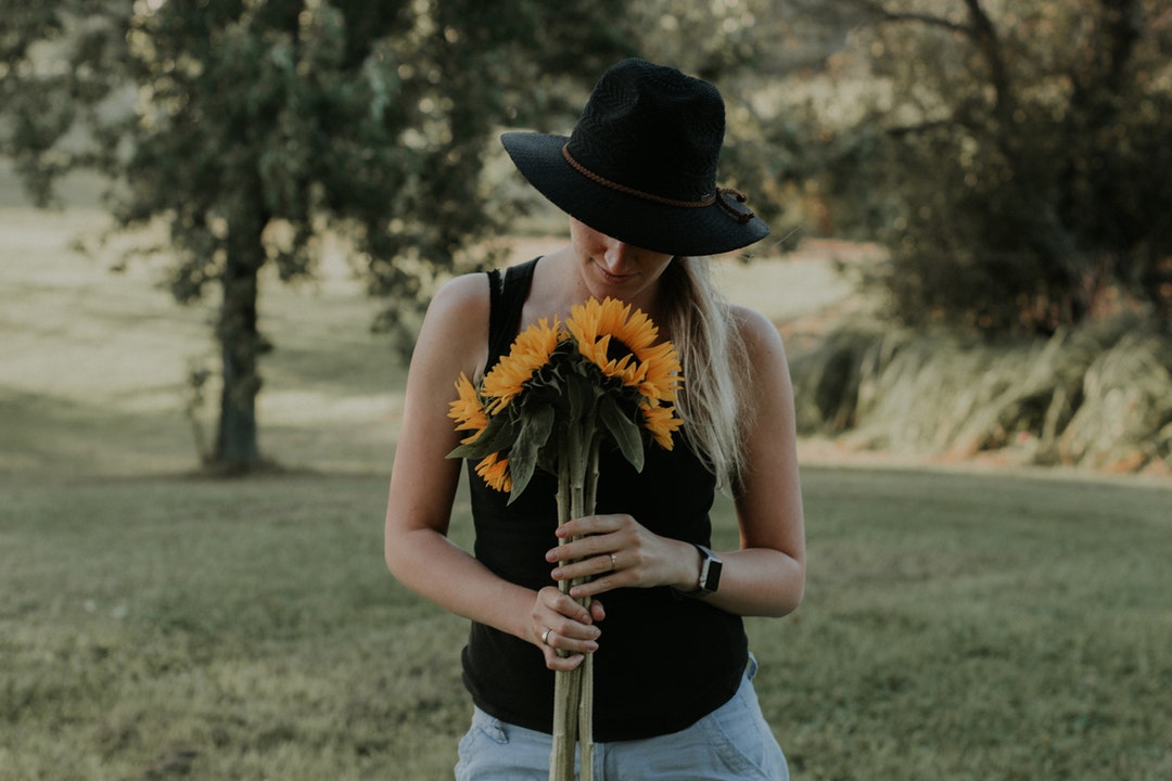 woman holding bouquet of sunflowers