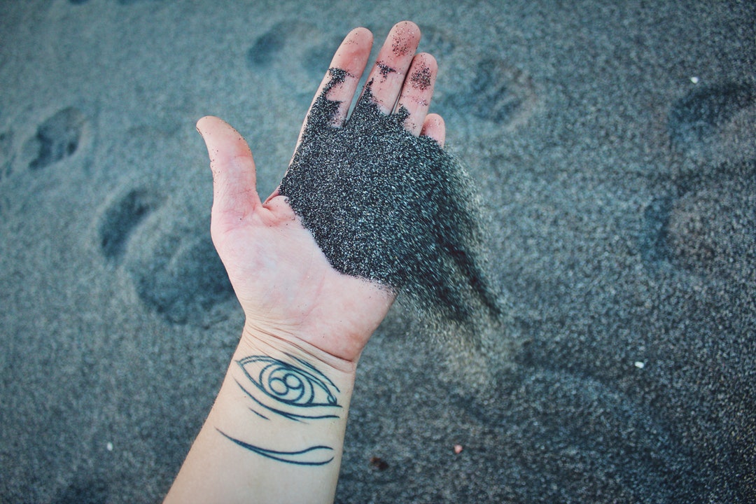 person holding gray sand
