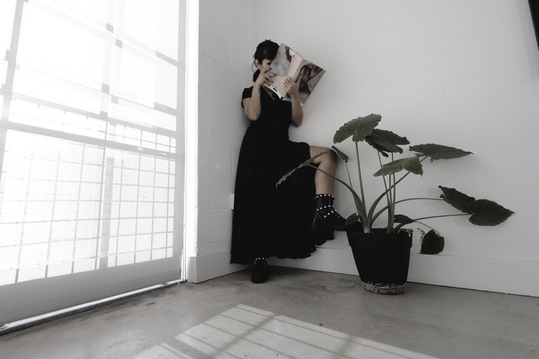 woman in black dress reading book