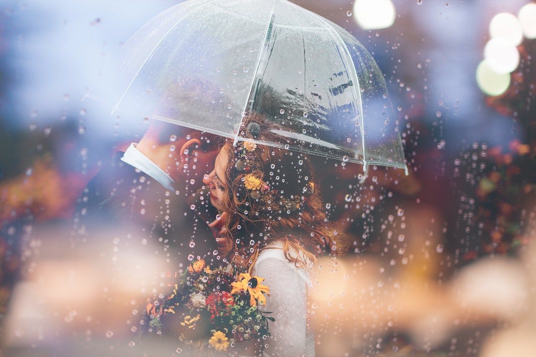 photo of woman hugging man under clear umbrella