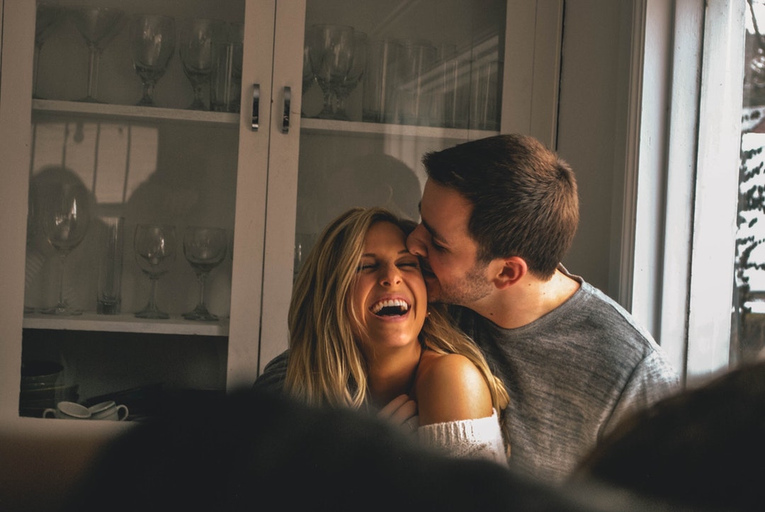 man kissing her girl on forhead