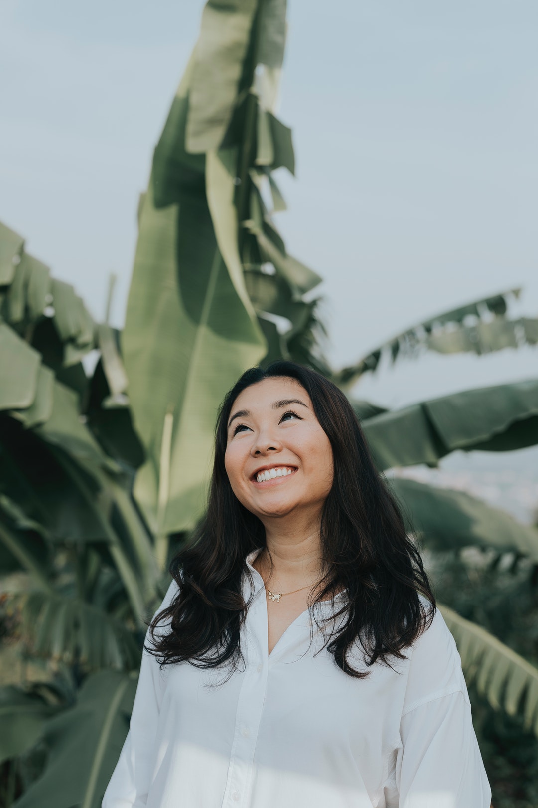 smiling woman in white button-up long-sleeved blouse