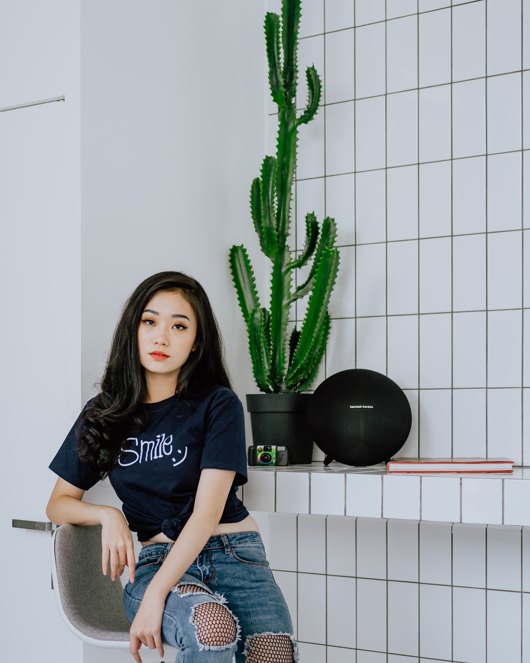 woman sitting on chair beside potted cactus