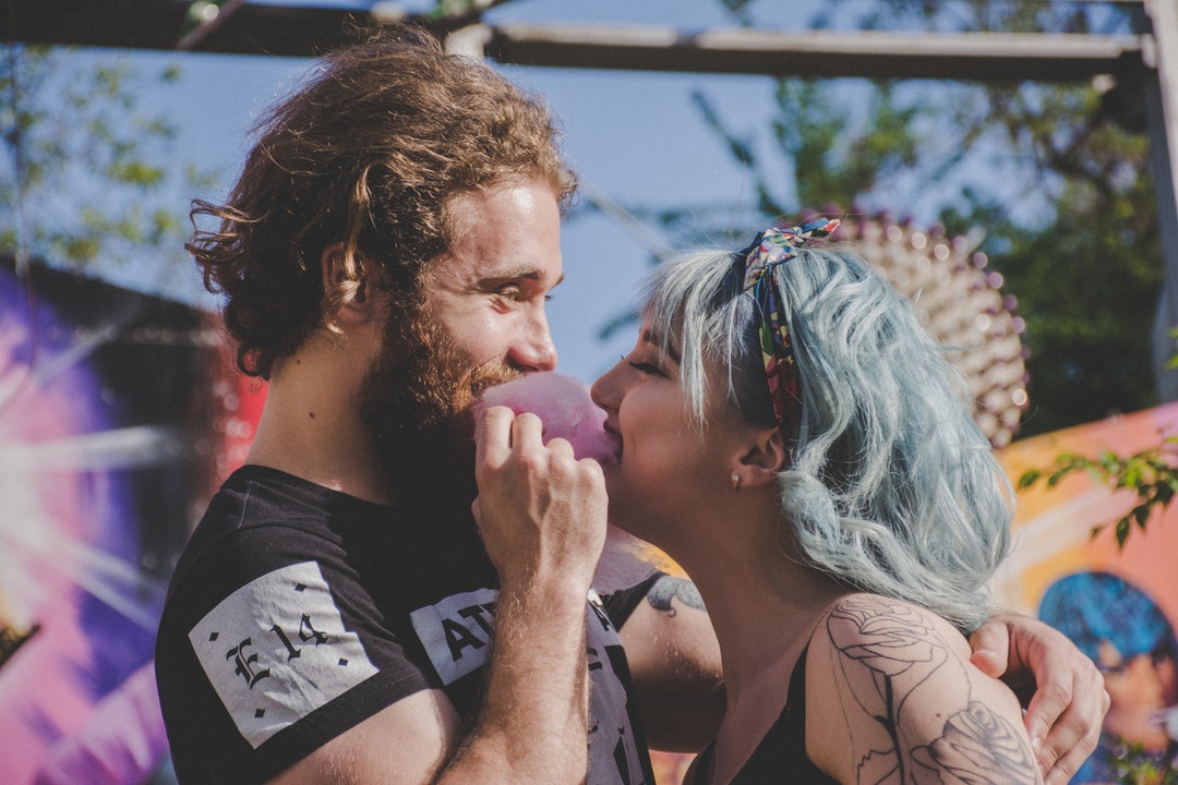 man and woman biting cotton candy