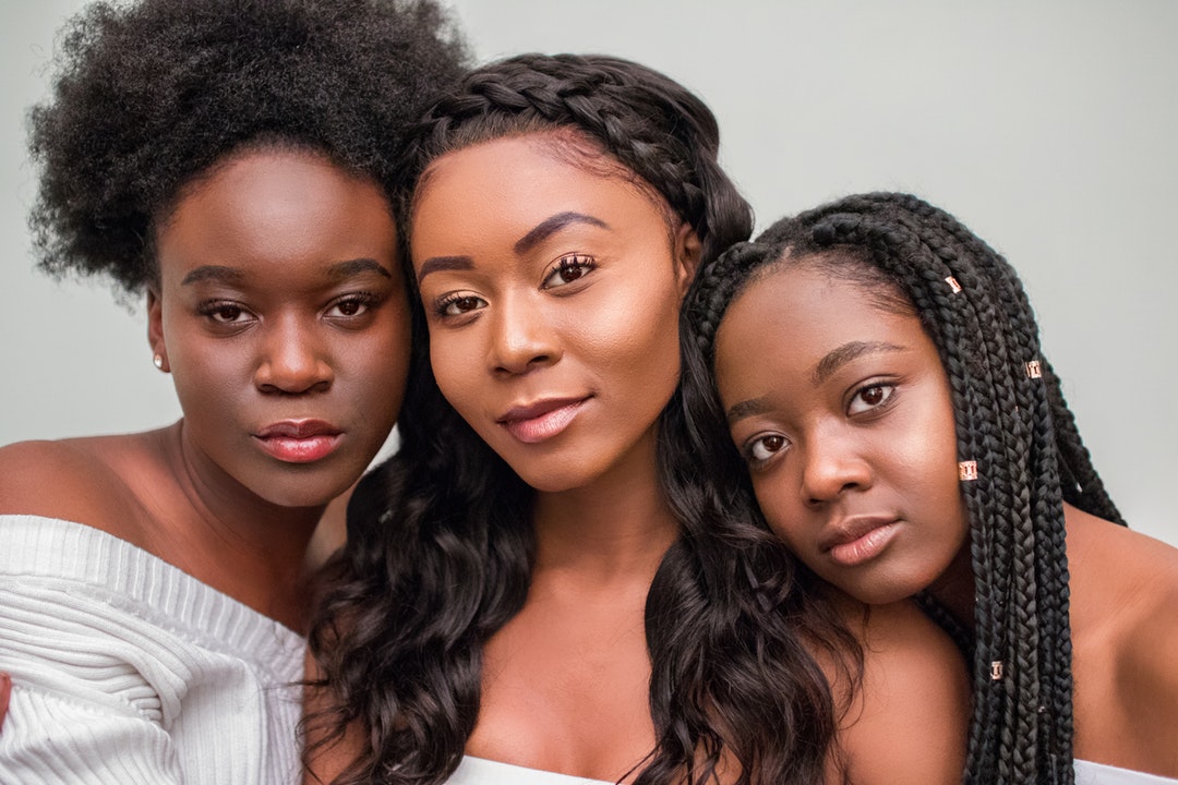 three women taking photo wearing white tops