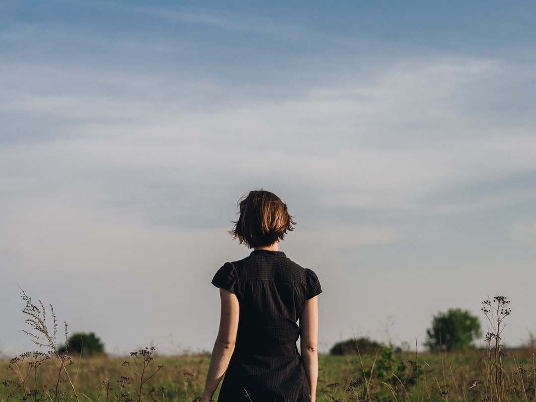 woman in black shirt standing in grass field