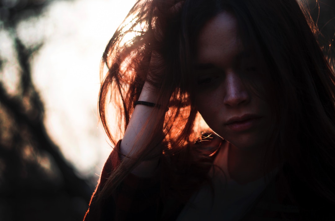 woman left hand on hair under sunset