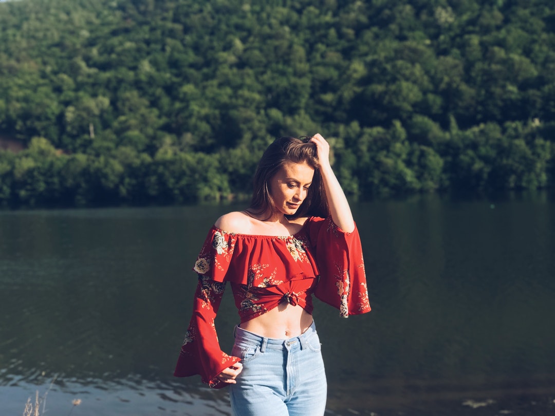 woman wearing off-shoulder crop top while holding her hair