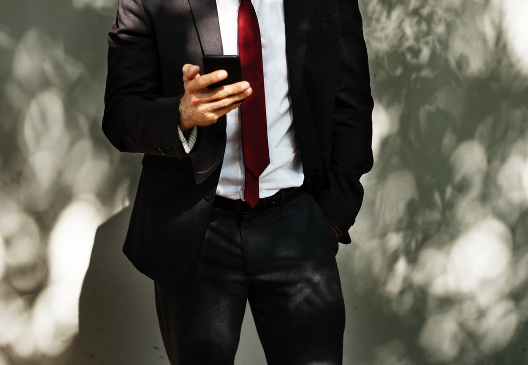 man standing while holding smartphone