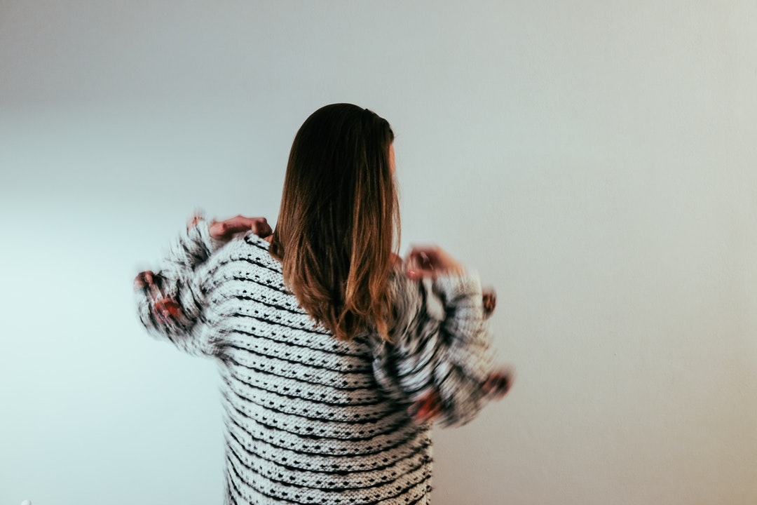 person standing behind white wall