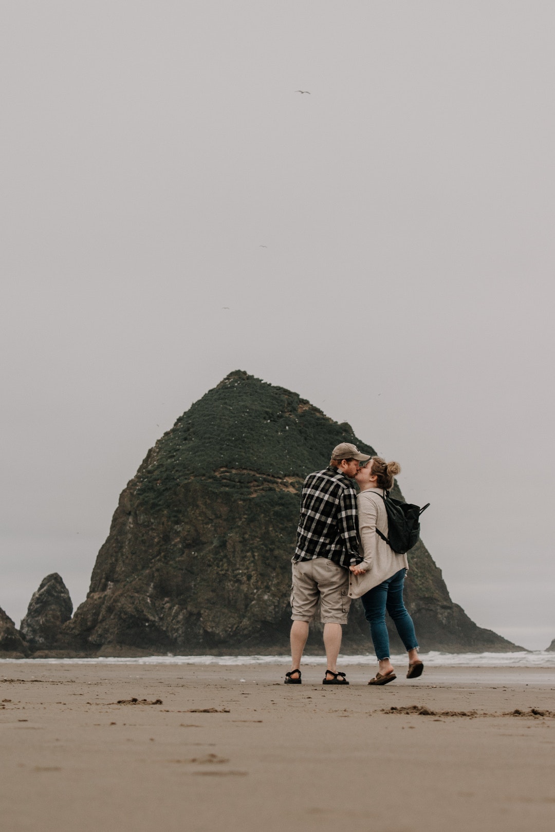man and woman kissing near islet