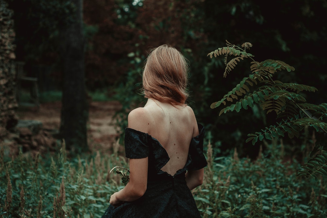 selective focus photography of woman standing on forest