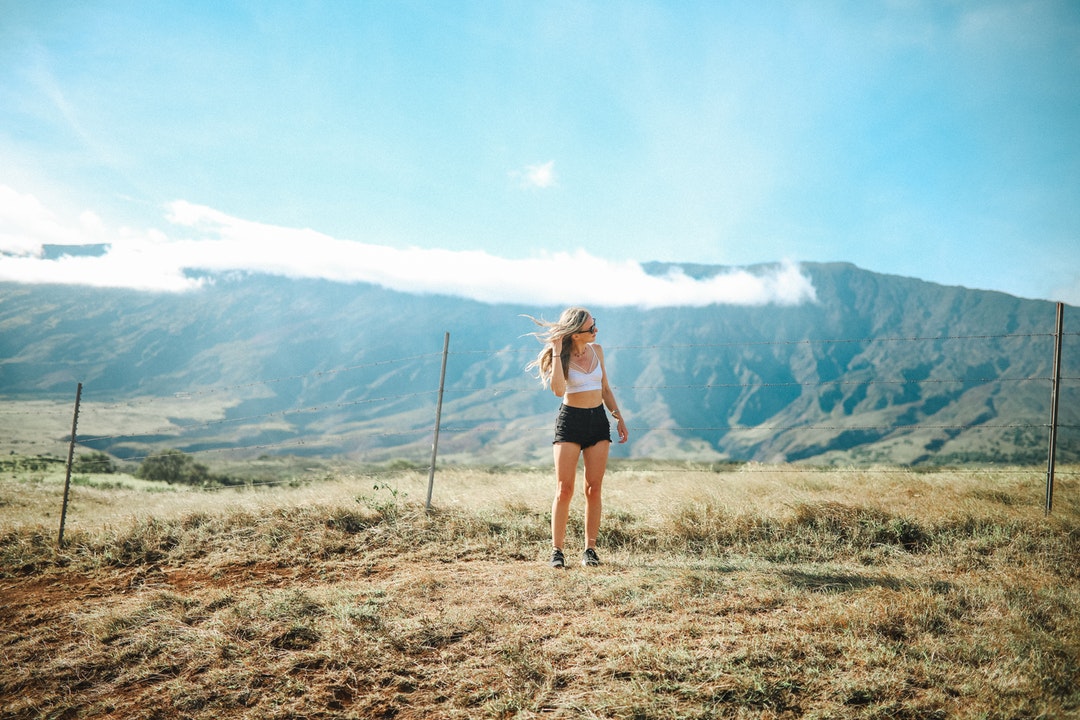 woman standing on grass field near posts