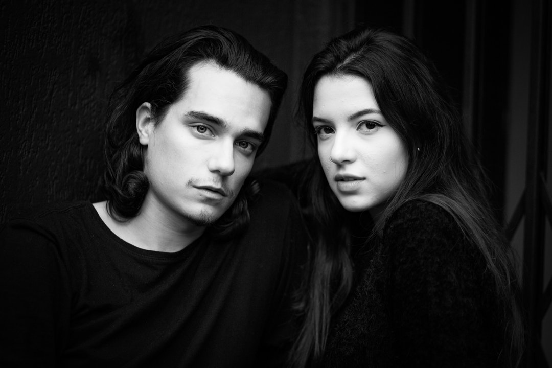 grayscale photo of man and woman wearing black shirts