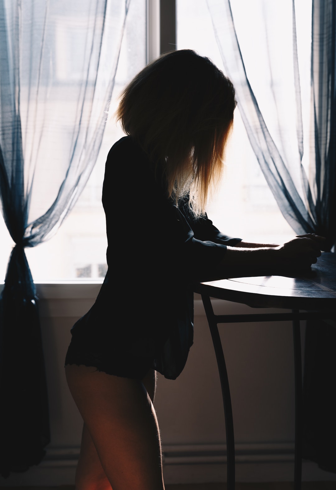 woman standing near glass window during daytime