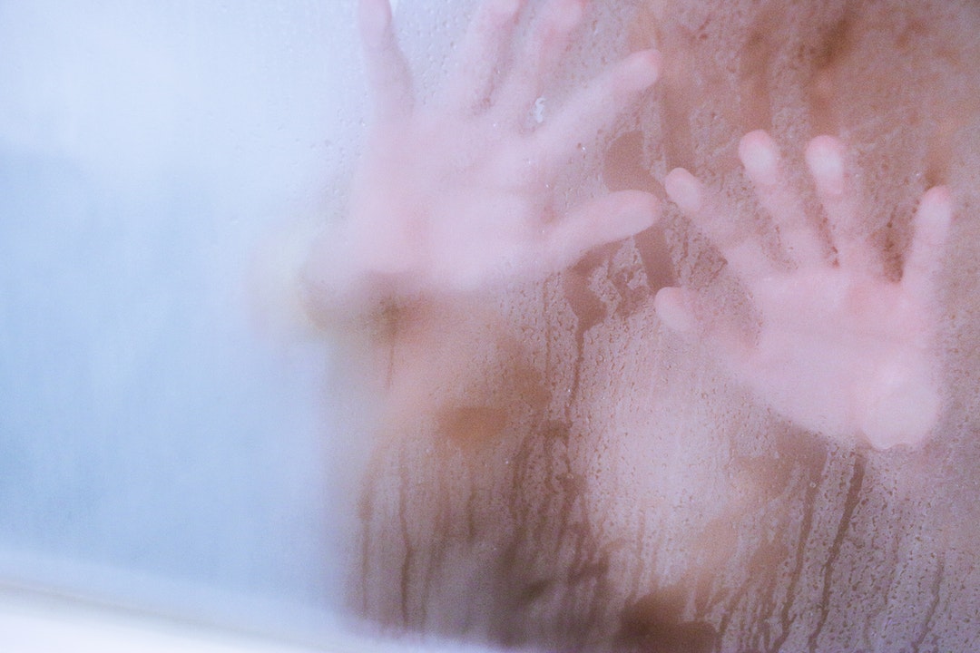 person in clear glass shower stall