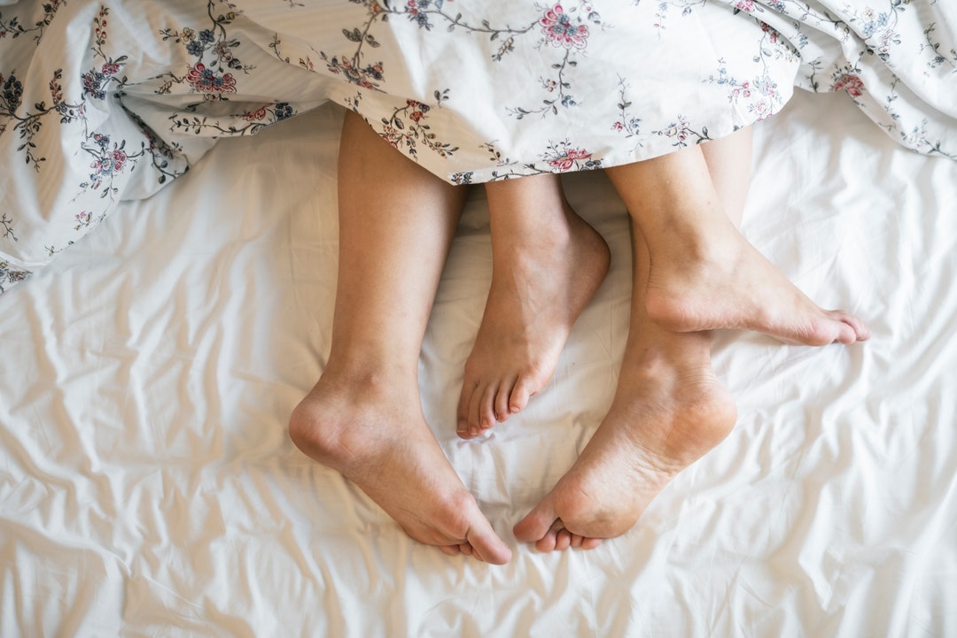 feet of two people on bed