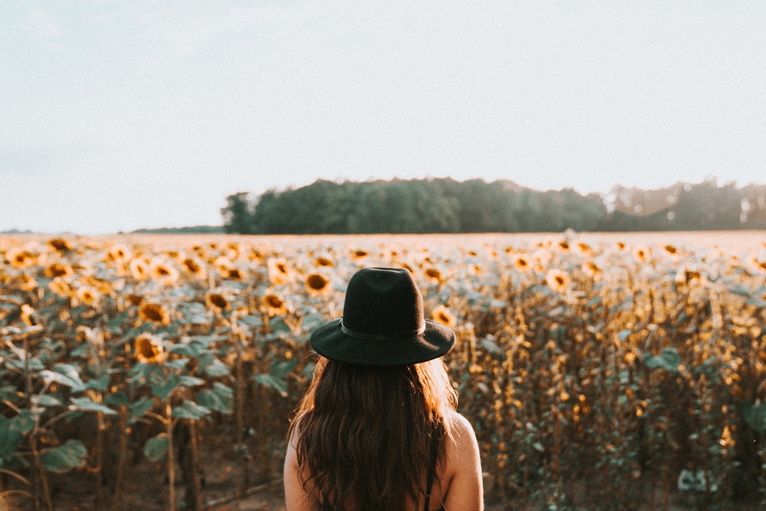 woman standing on sunflower garden