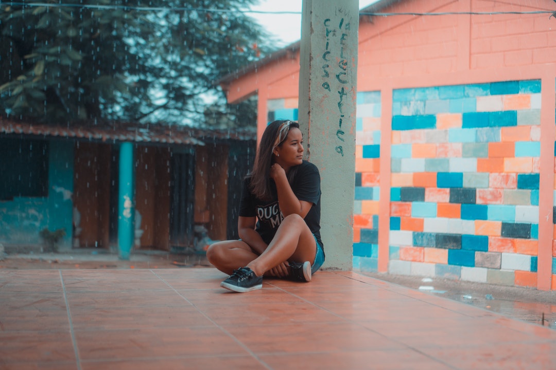 woman sitting on brown surface