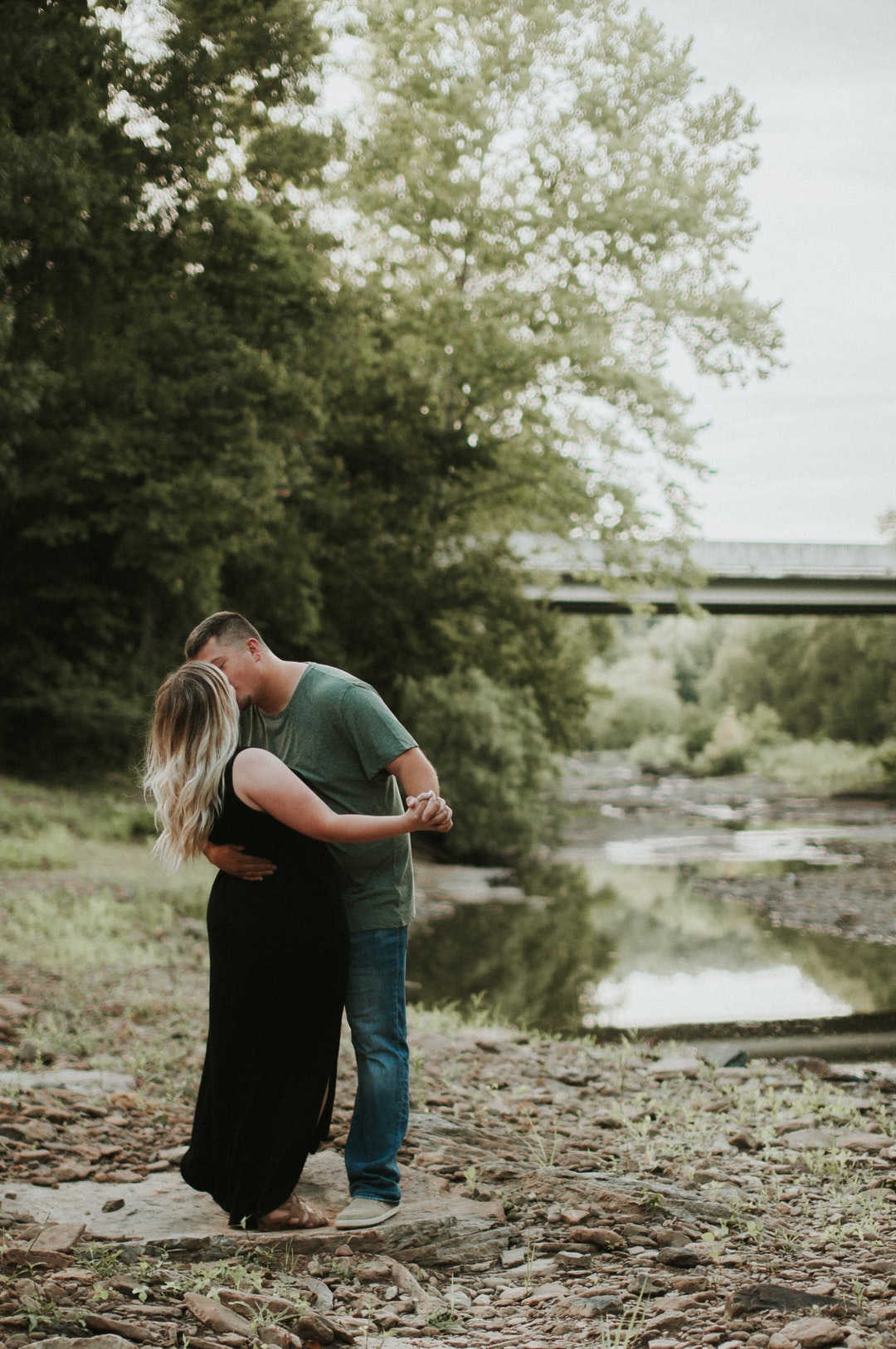 man kissing woman beside the river