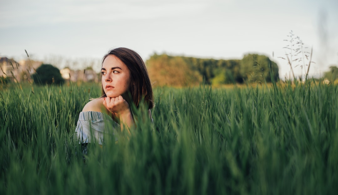 selective focus photo of woman near grass field