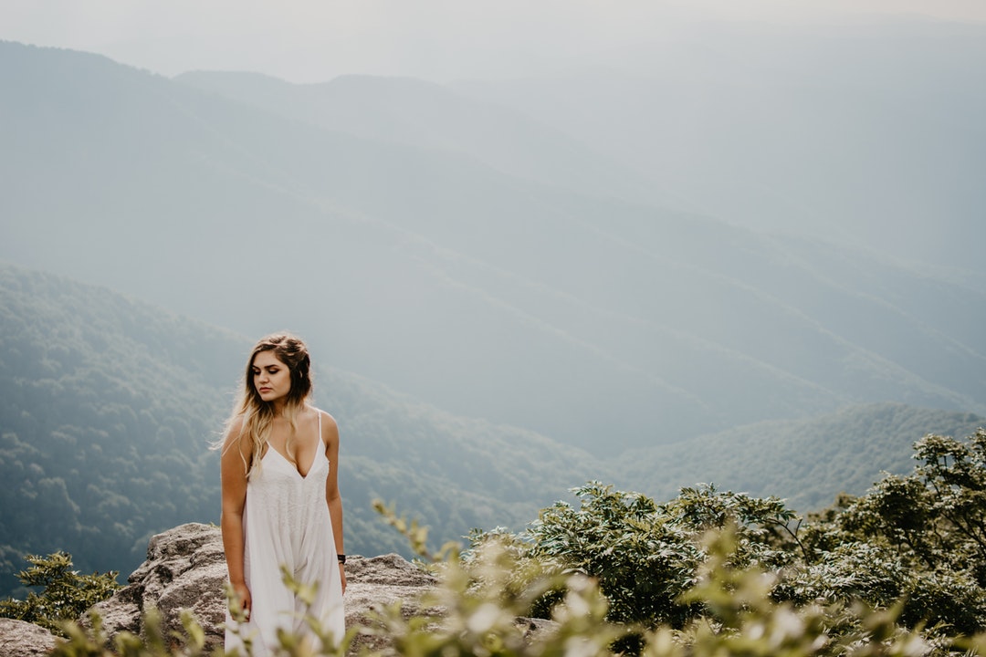 woman standing on brown rocky terrain at high altitude