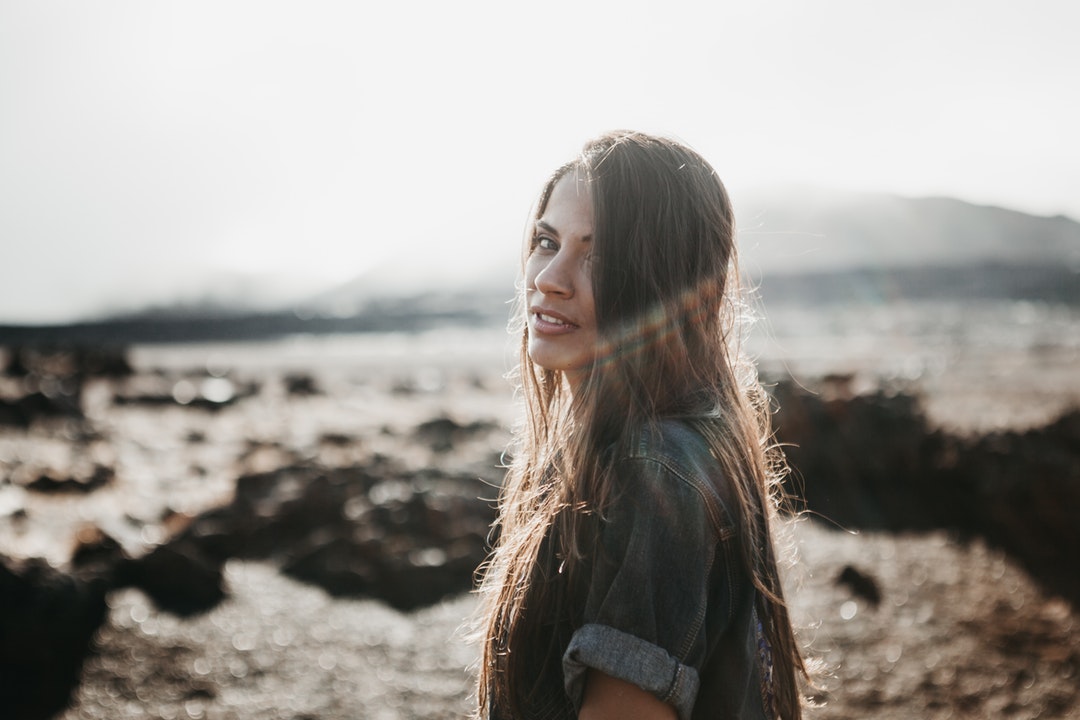 woman in grey top near body of water