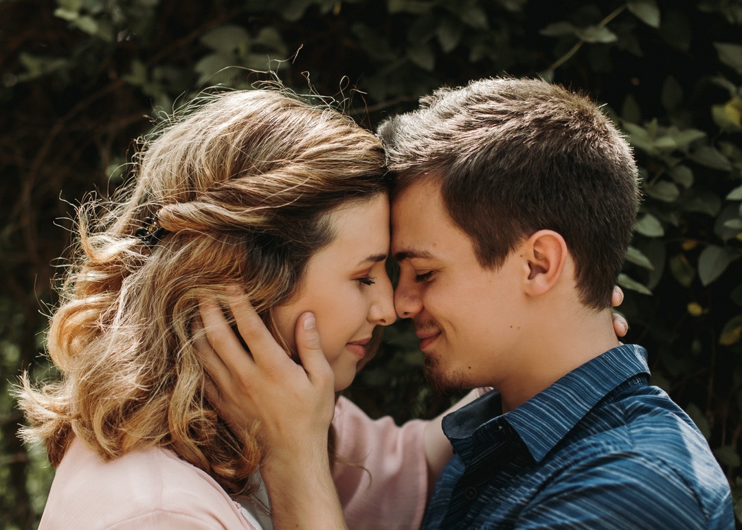 man and woman closing eyes while smiling