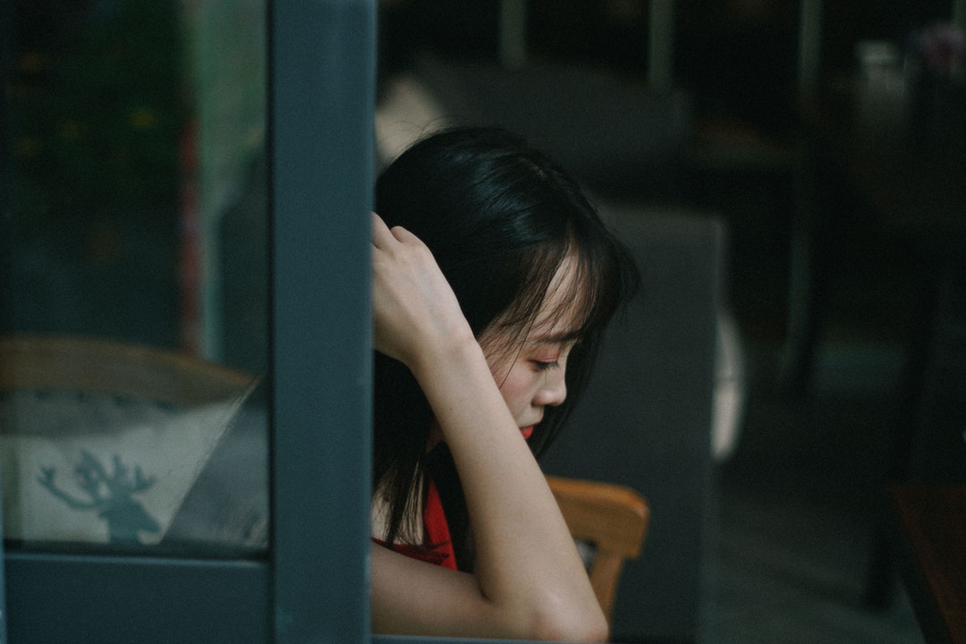woman sitting down with hand near hair