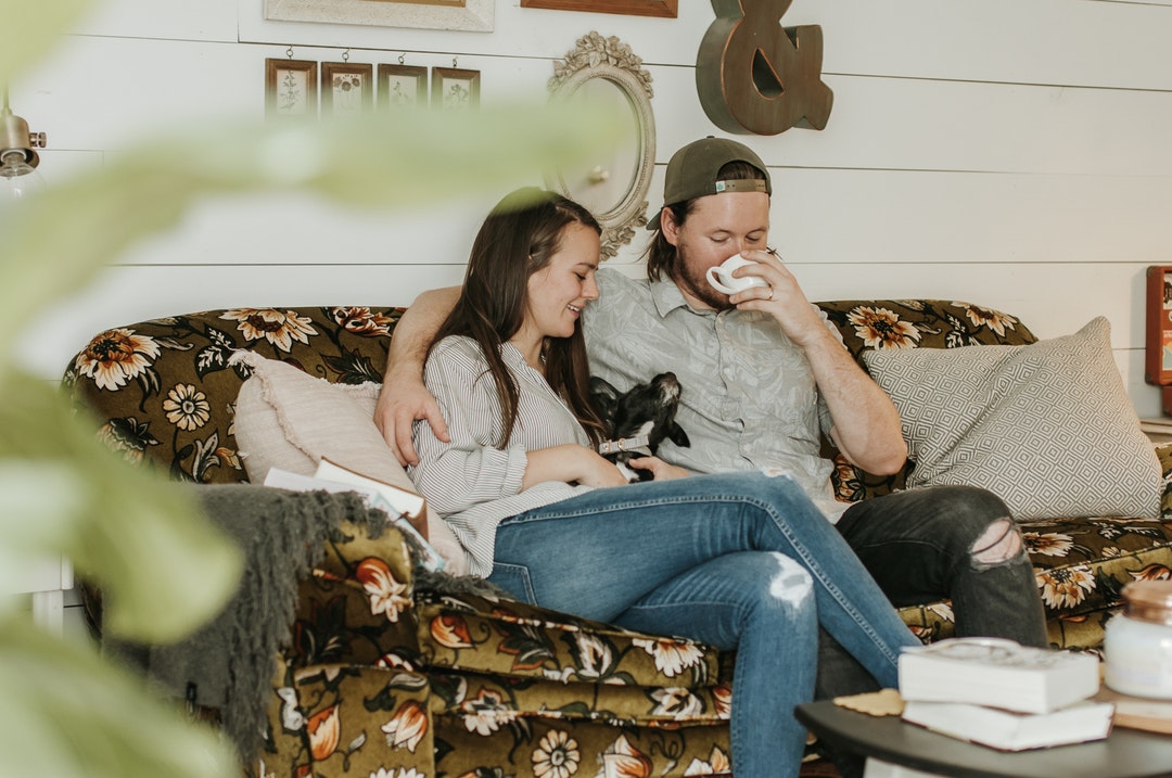 photo of man and woman sitting on sofa
