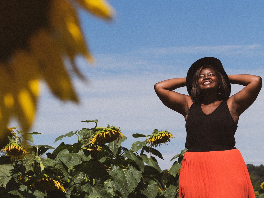 woman in black tank top in sunflower field during daytime