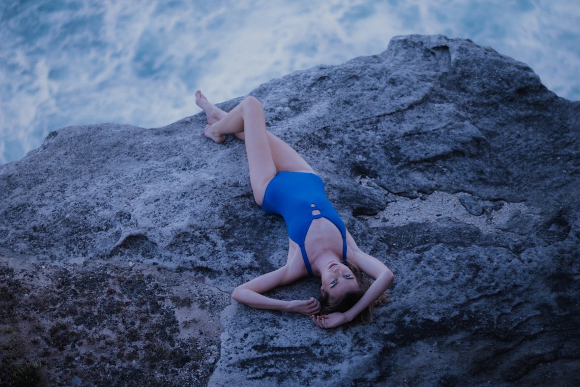girl laying on a rock