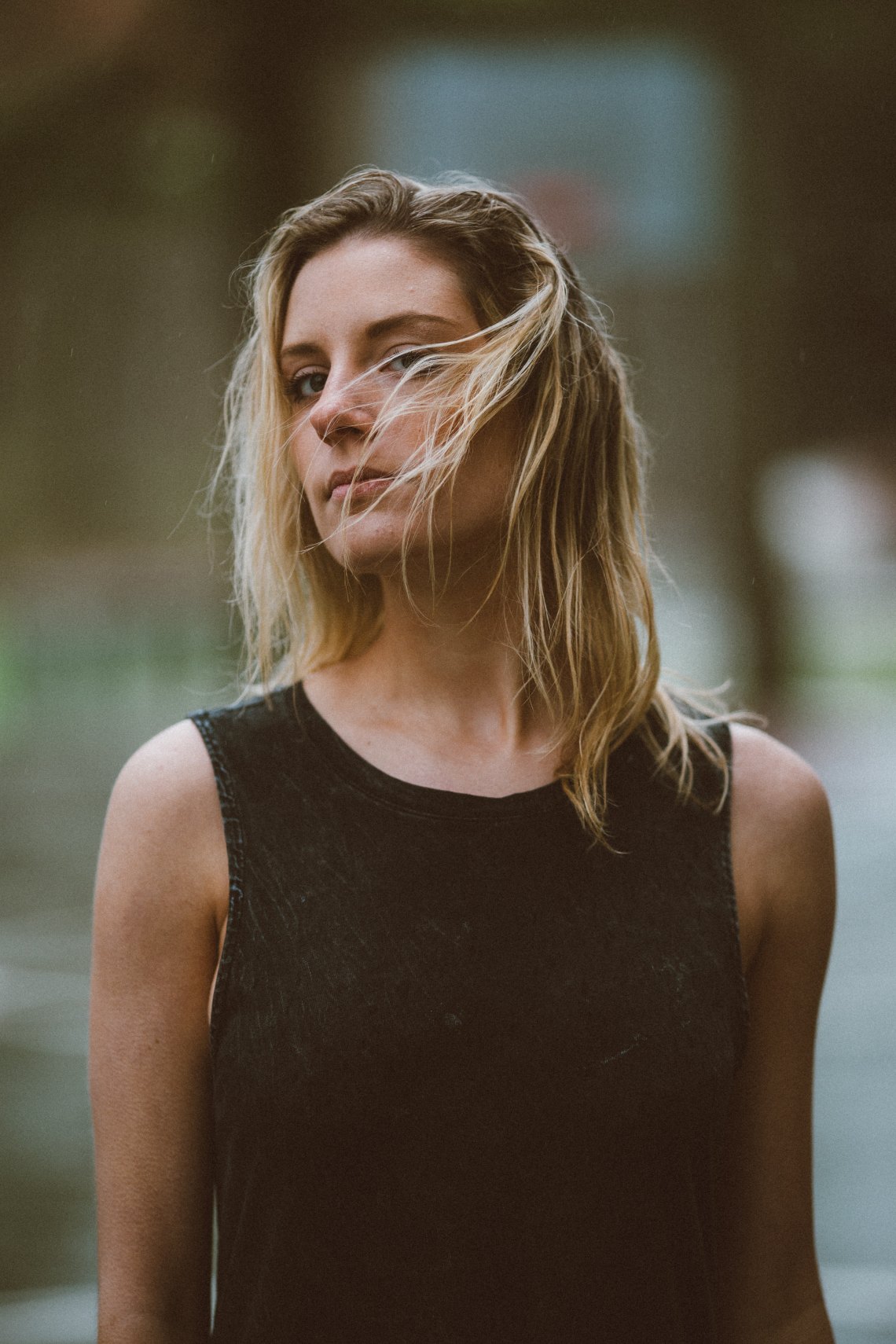 girl standing and looking as her hair blows in her face