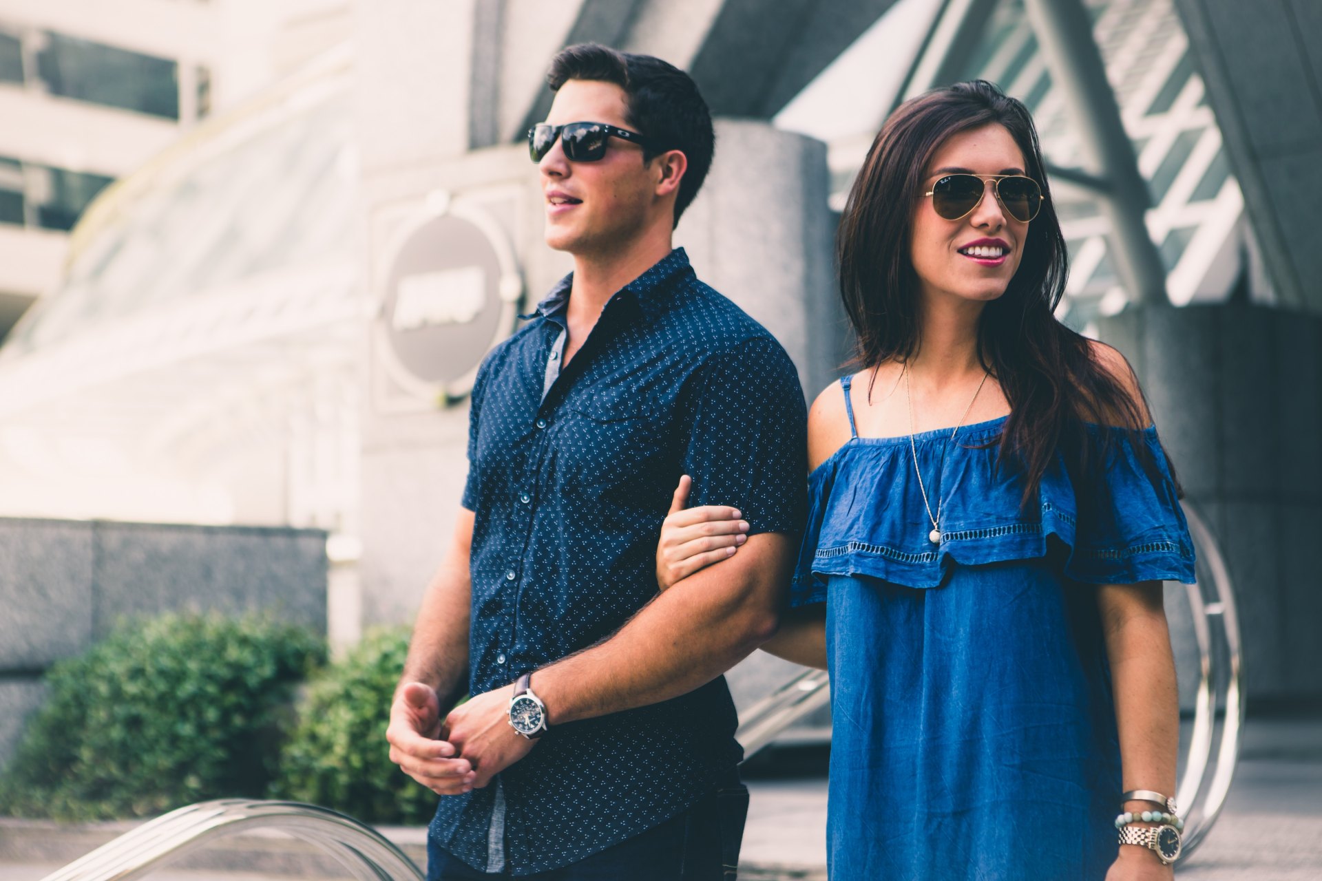girl and guy walking and leading each other in sunglasses