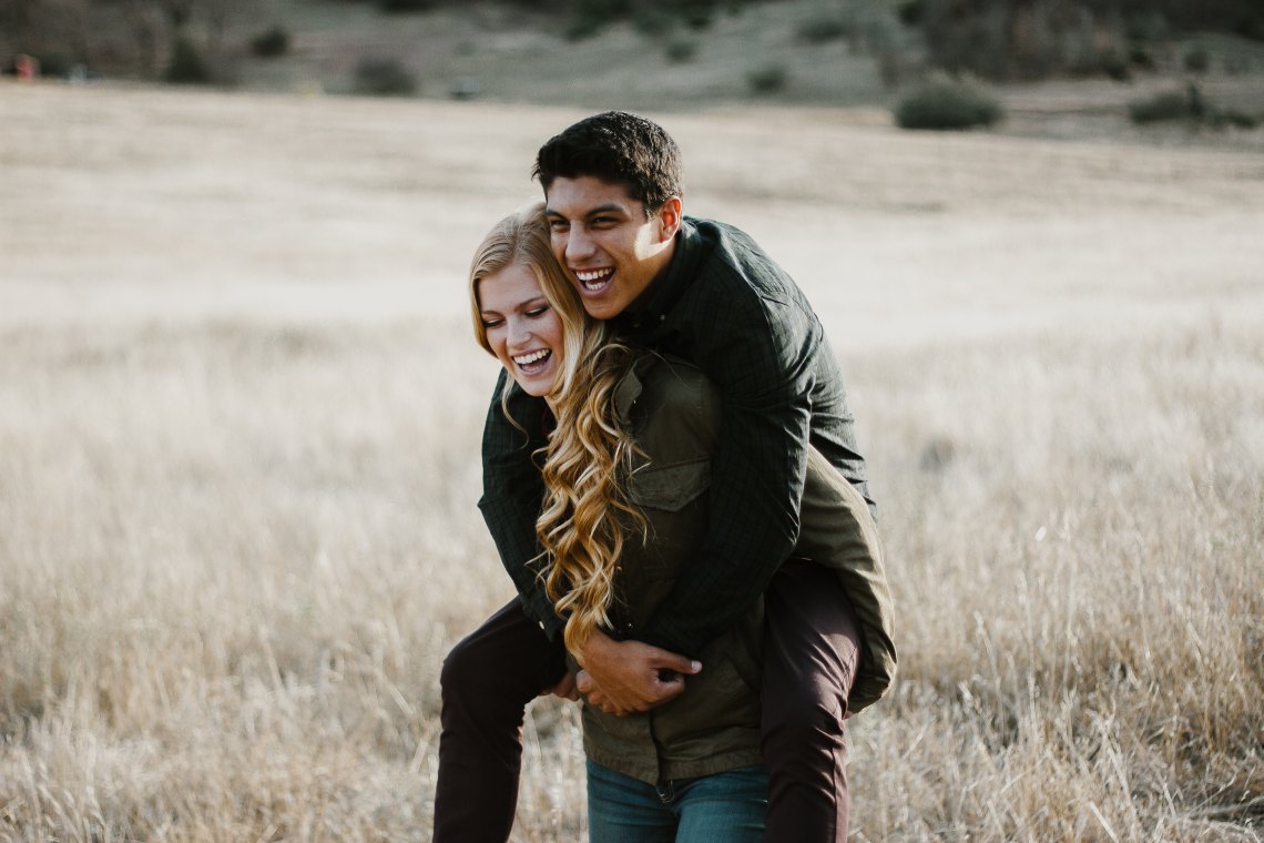 couple giving a piggyback ride in a field
