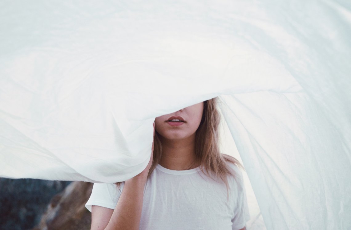 girl with a white sheet over her face