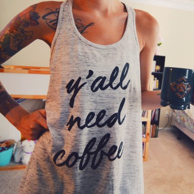 girl drinking coffee in the morning wearing a y'all need coffee tank top