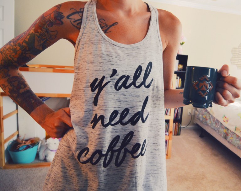 girl drinking coffee in the morning wearing a y'all need coffee tank top