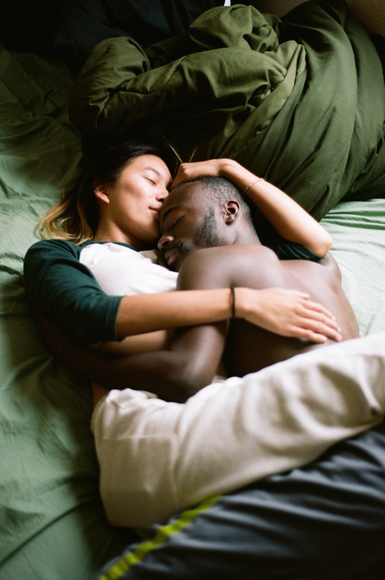 Man and woman embracing, intimate in bed, in love, comforting, cradling, taking care of each other