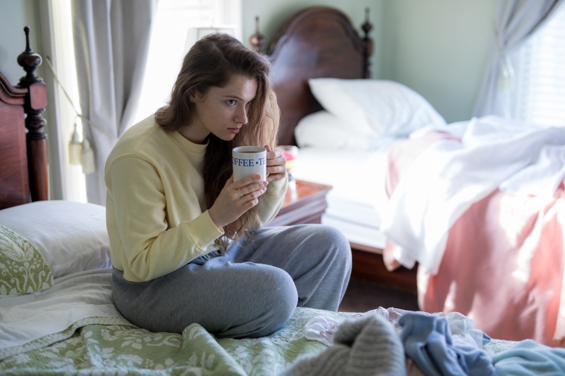 girl sipping coffee on a bed