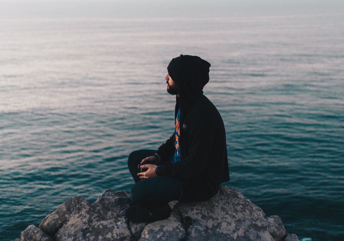 man meditating by water
