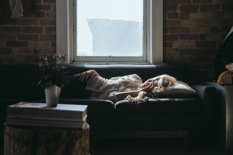 depressed woman sleeping on couch