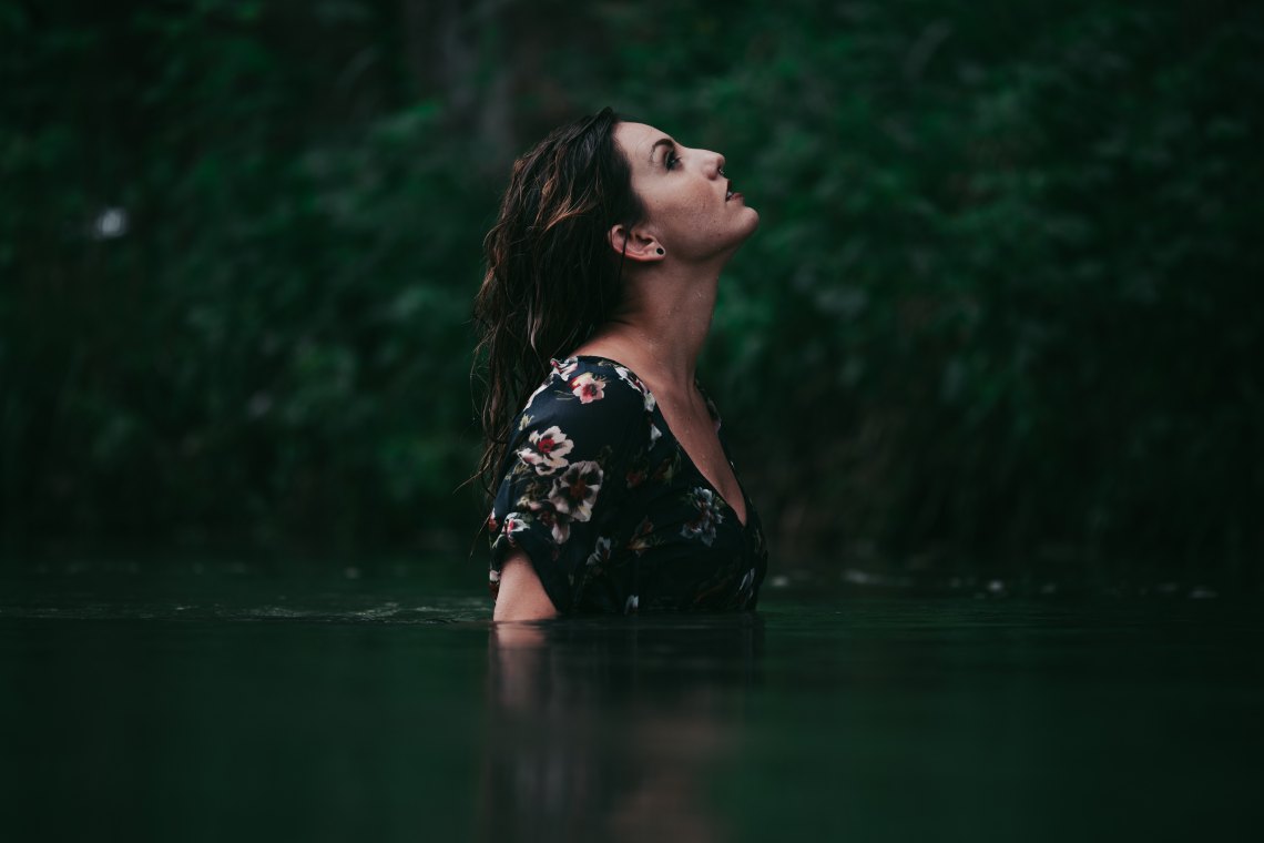woman looking up in forest
