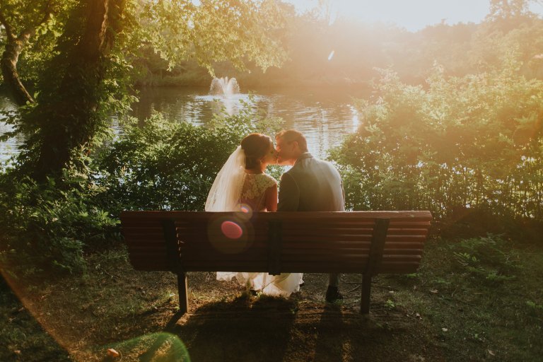 Wedding couple kissing on bench