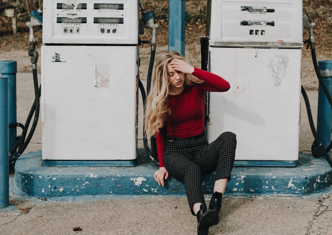 woman sitting by gas pumps