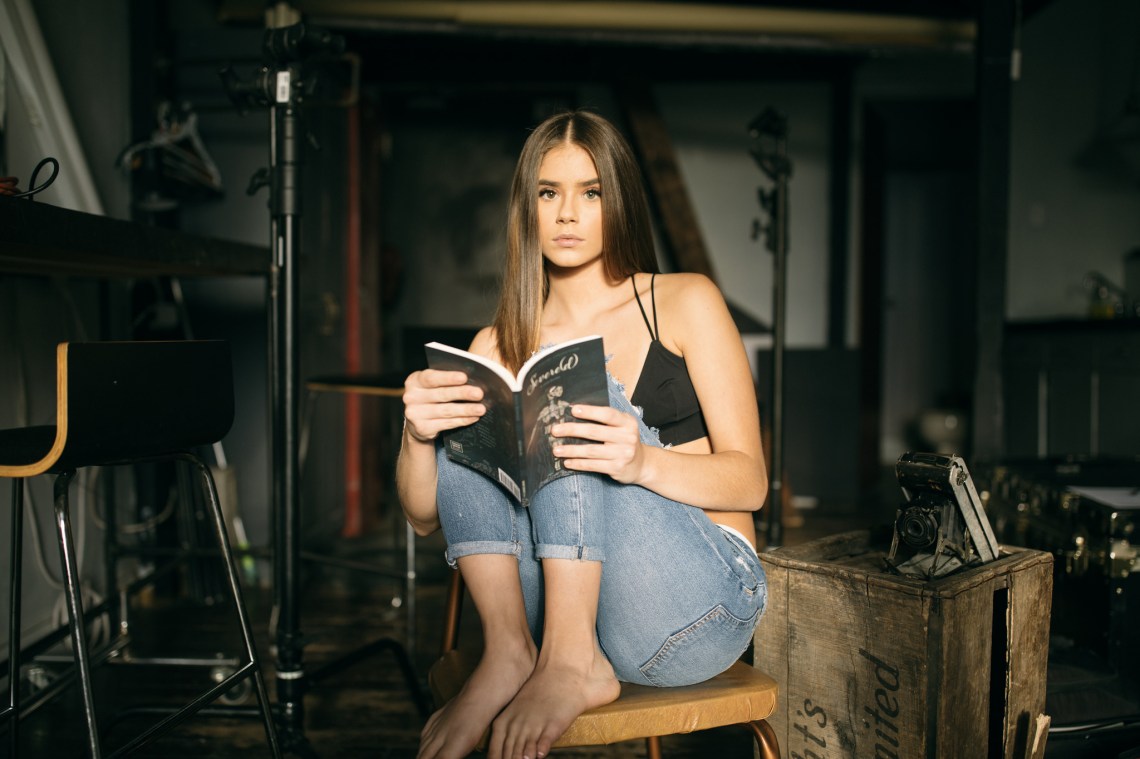 pretty woman reading book in city apartment